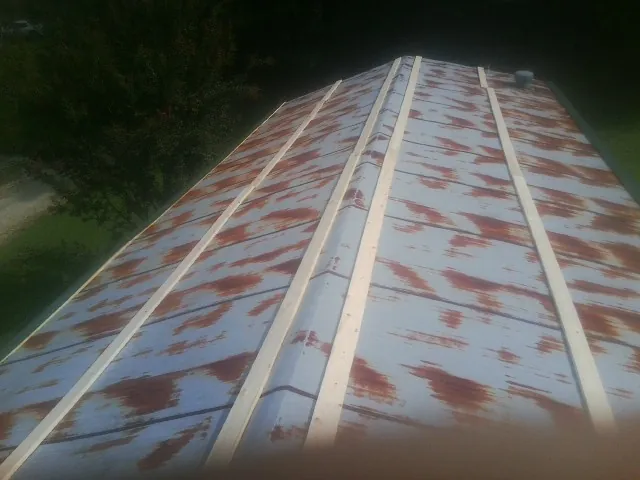 Rusted metal roof panels with new wood purlins before replacement — Storm Damage Roof Repair in State Farm by Roofing Brothers
