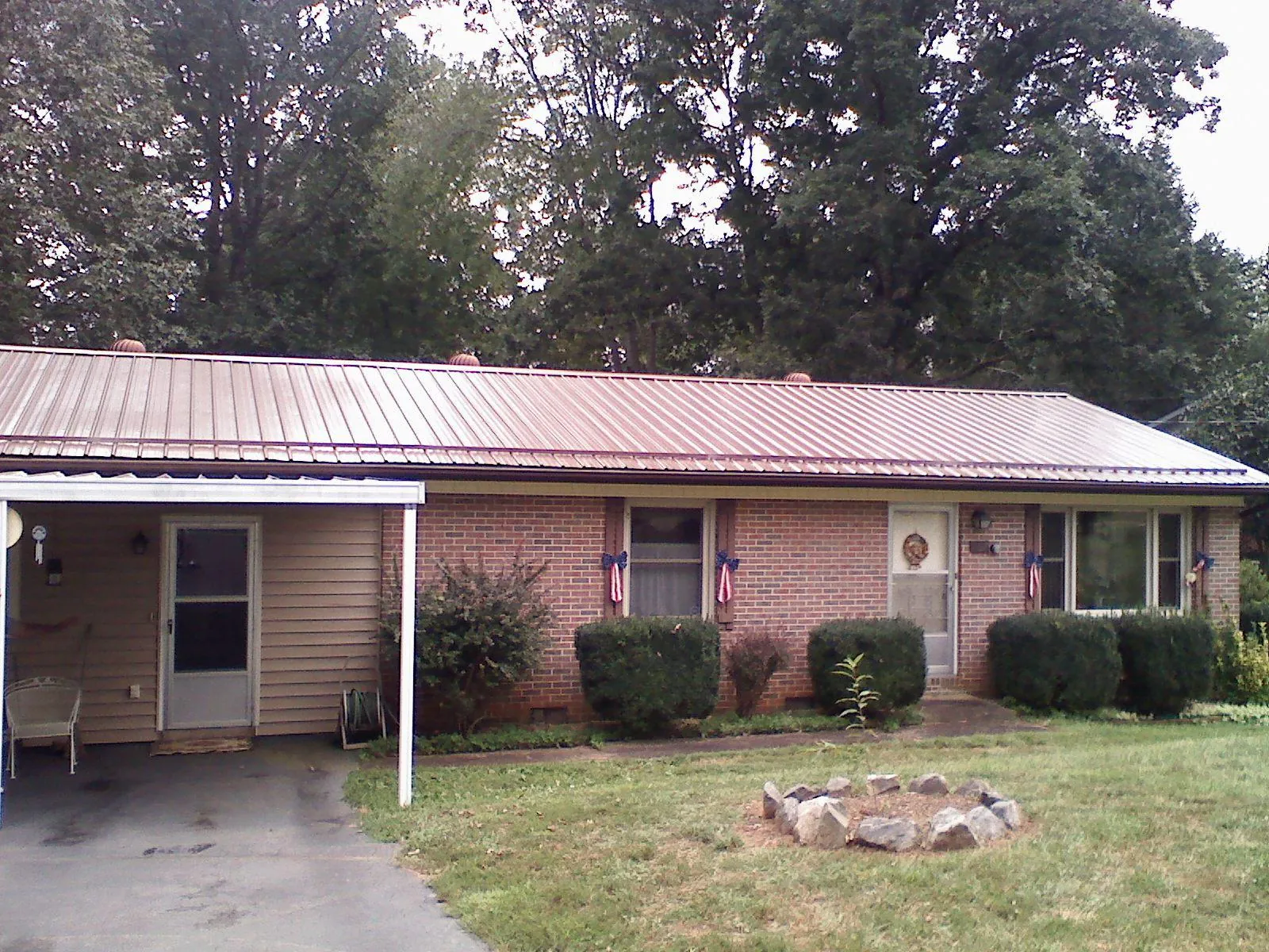 Bronze metal roof and carport on a brick ranch home — Roof Repair work by our crew in State Farm